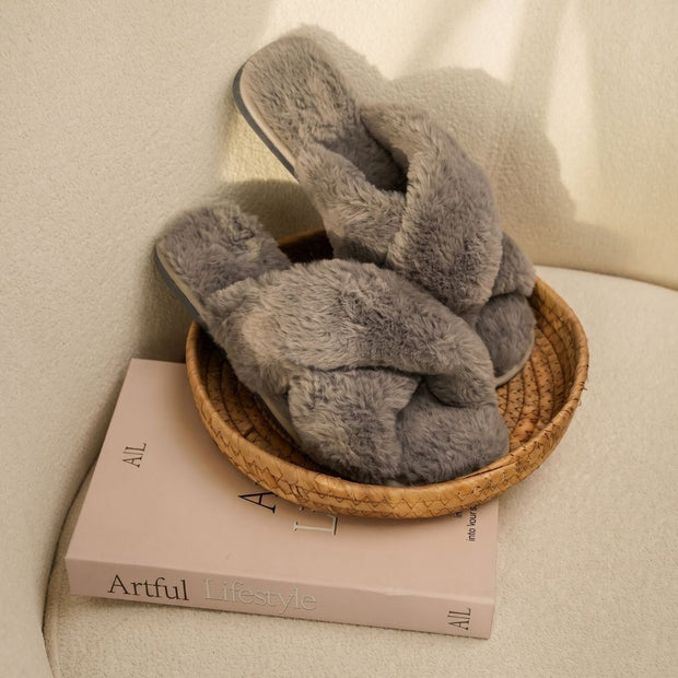 BELSTA The Ash Fluffy Slippers — grey plush crossover slides on a book in a wicker tray, lifestyle shot