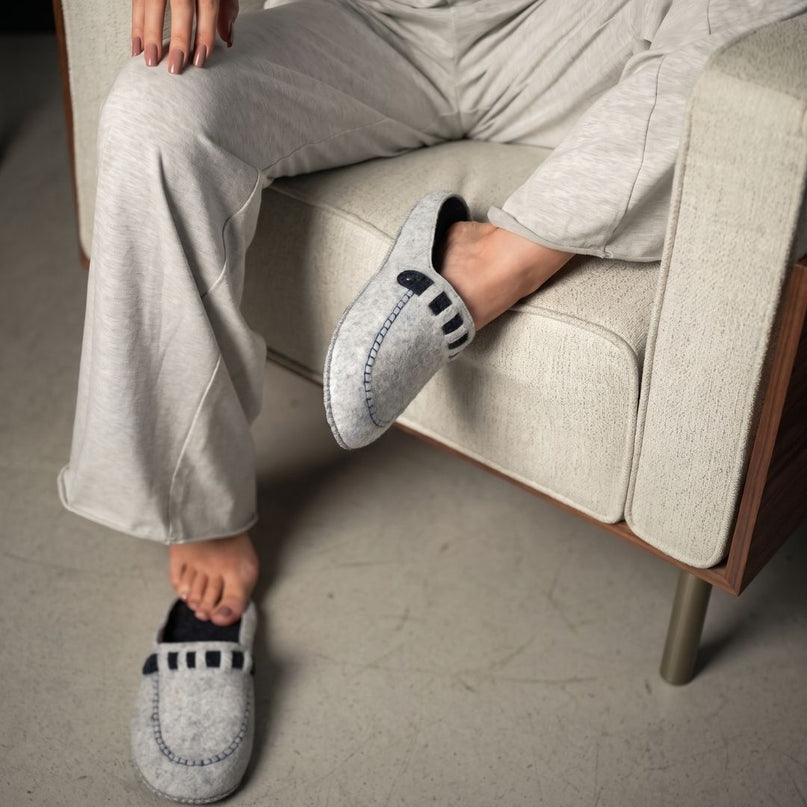 Close-up of BELSTA The Fog Felt Slippers worn with light grey loungewear — grey felt loafer slippers with black strap